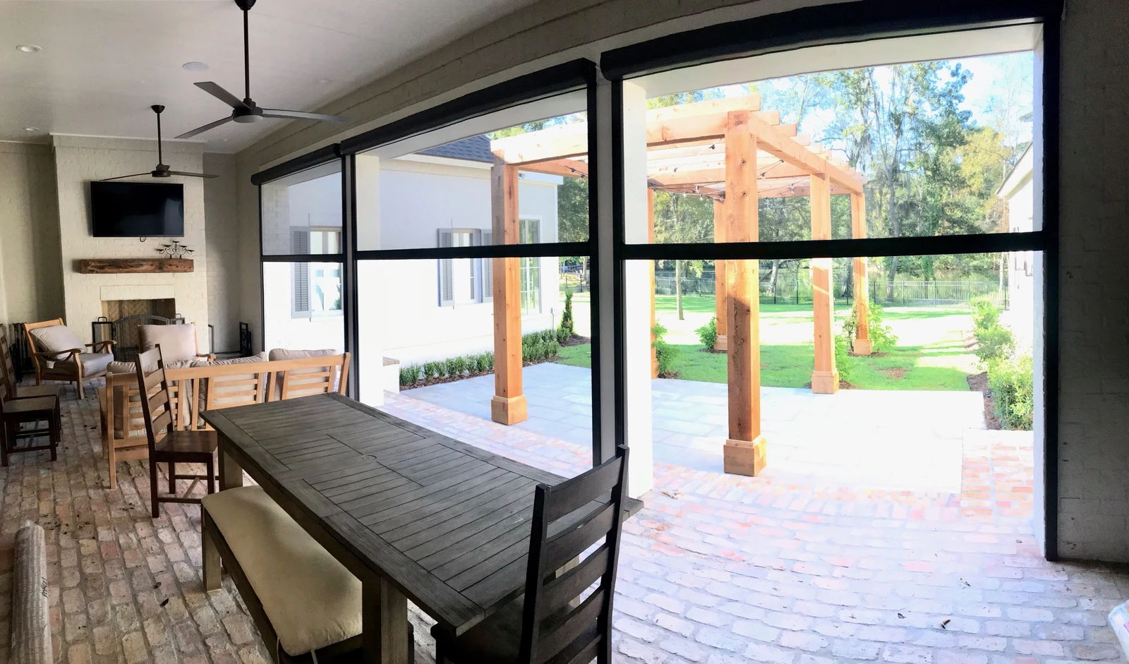 Retractable screens surrounding an outdoor dining and kitchen area