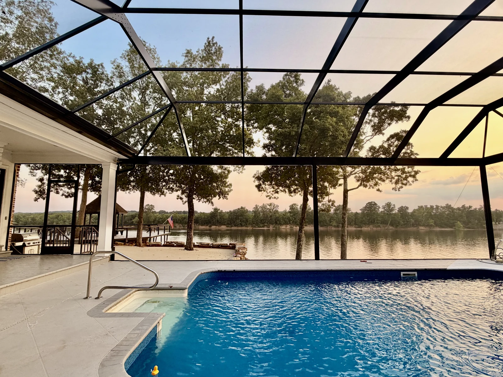 A custom Adams Aluminum pool enclosure overlooking a lake