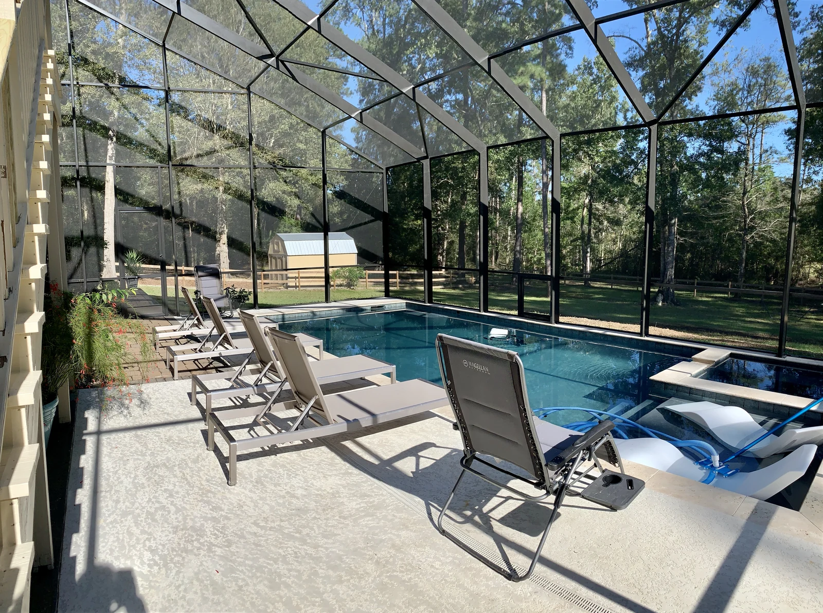 An enclosed pool and lounge area sheltered by custom aluminum framing