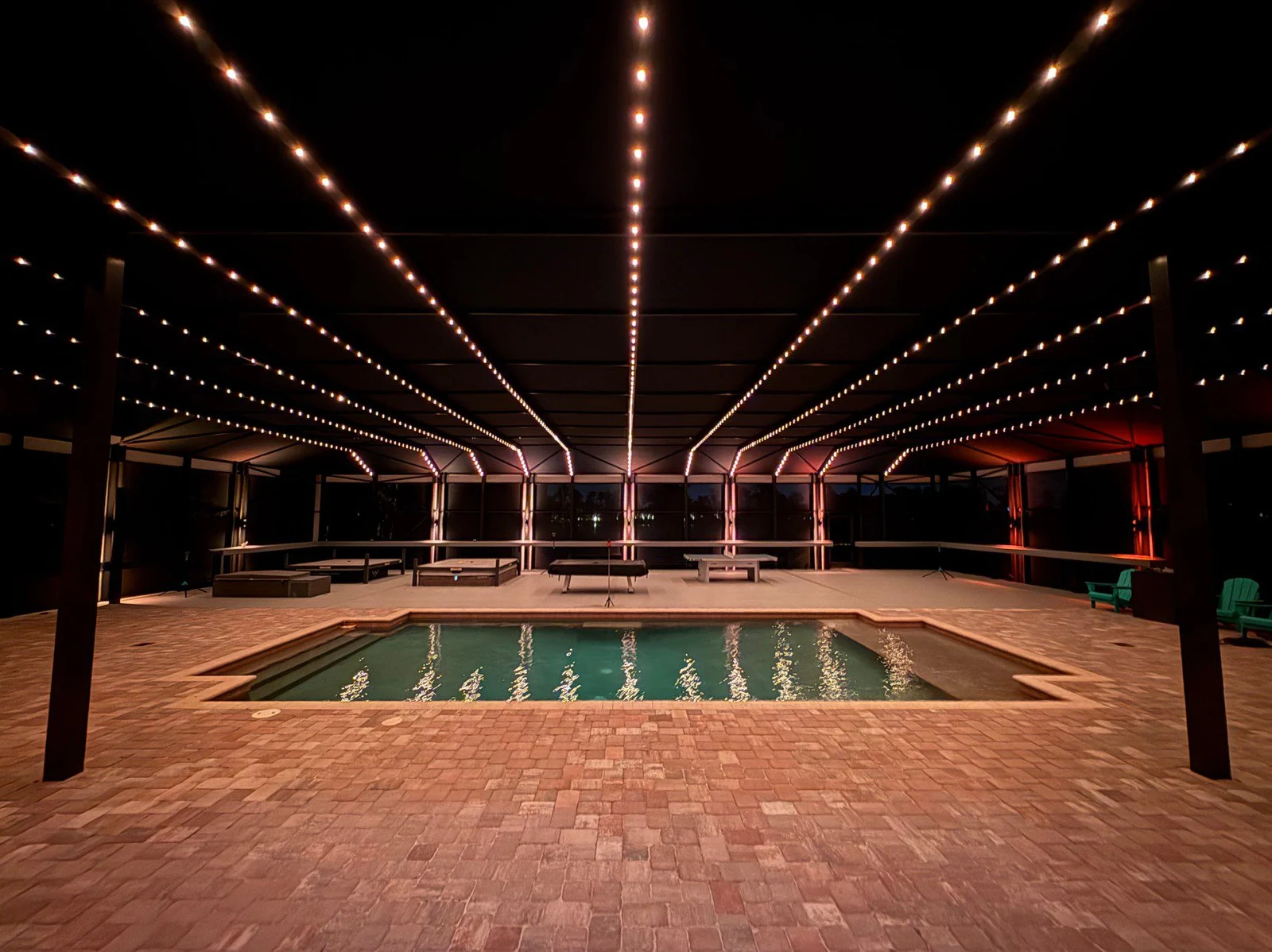 Integrated LED lighting illuminating a screened swimming pool at night